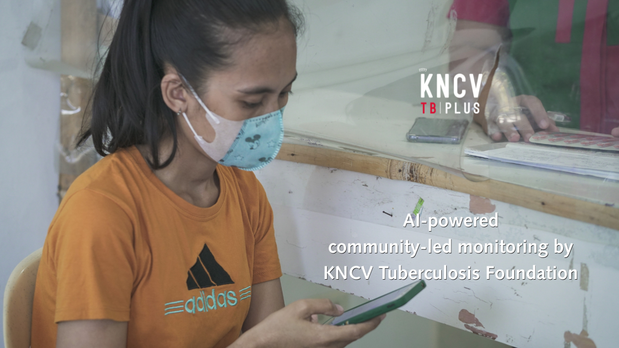 Person wearing face mask looking over phone. Overlay text reads: AI-powered community-led monitoring by KNCV Tuberculosis Foundation