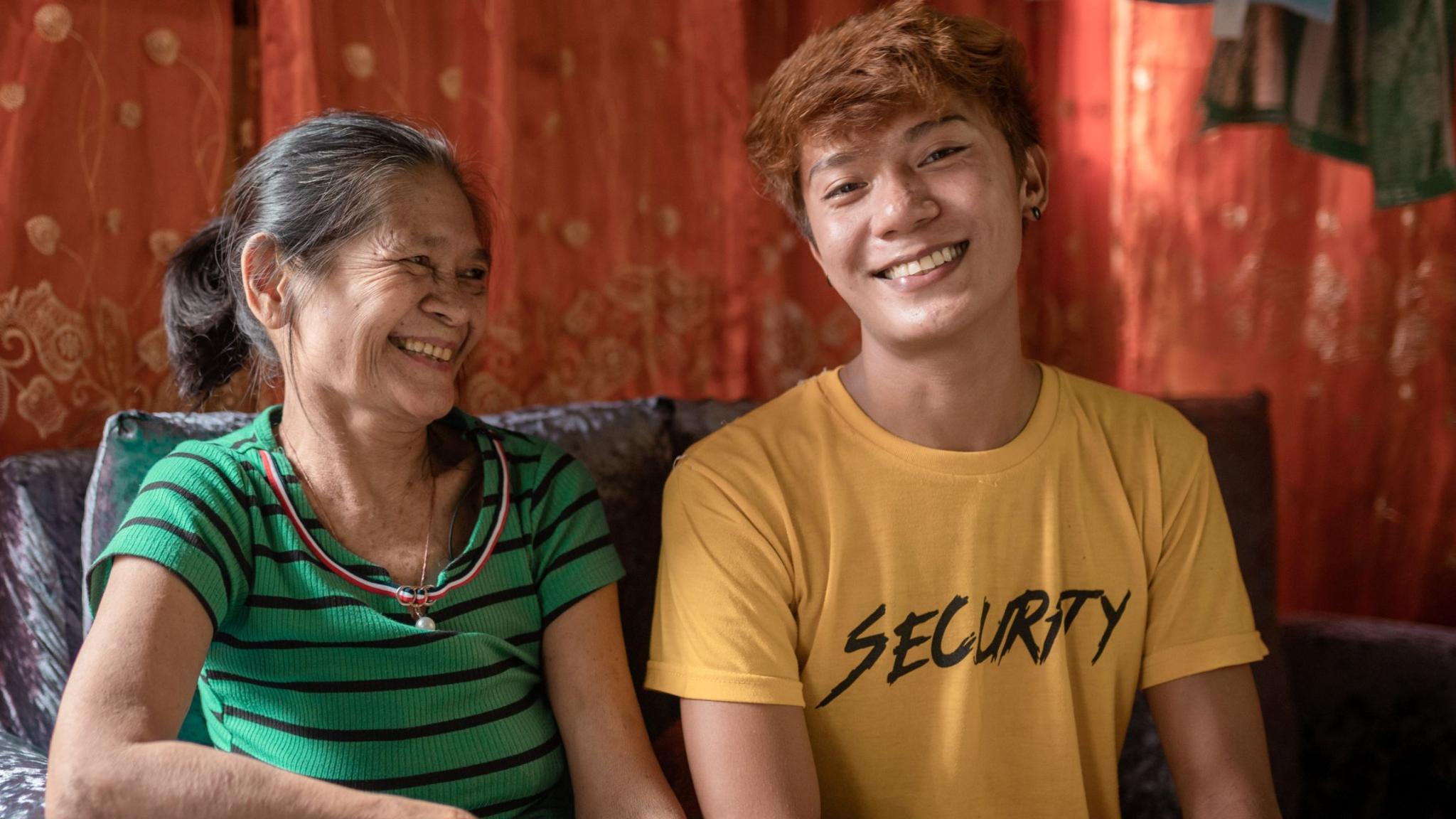 Filipina woman and her son sitting and smiling.