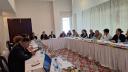 Several people sitting around desk in meeting in Dunshabe
