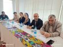 2 women and 4 men sitting behind desk attending a meeting in Dushanbe
