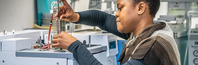 A employee of NIOZ working in the lab with some equipment in hands